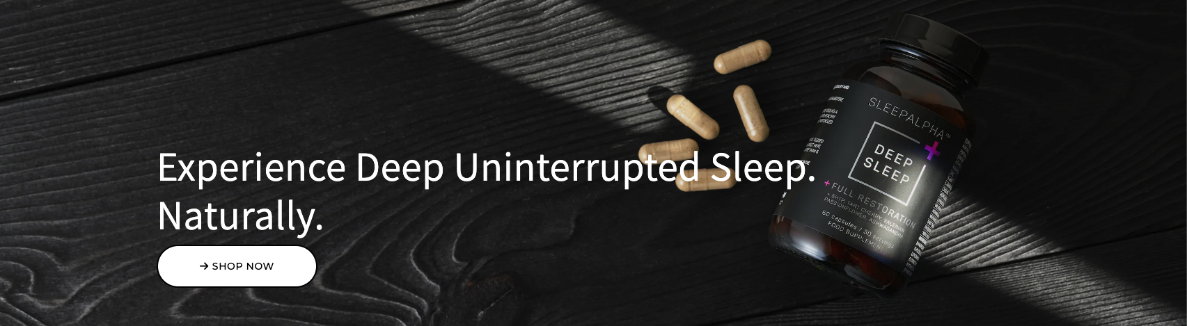 Supplement bottle and capsules on dark wood background with text: 'Experience Deep Uninterrupted Sleep. Naturally.'