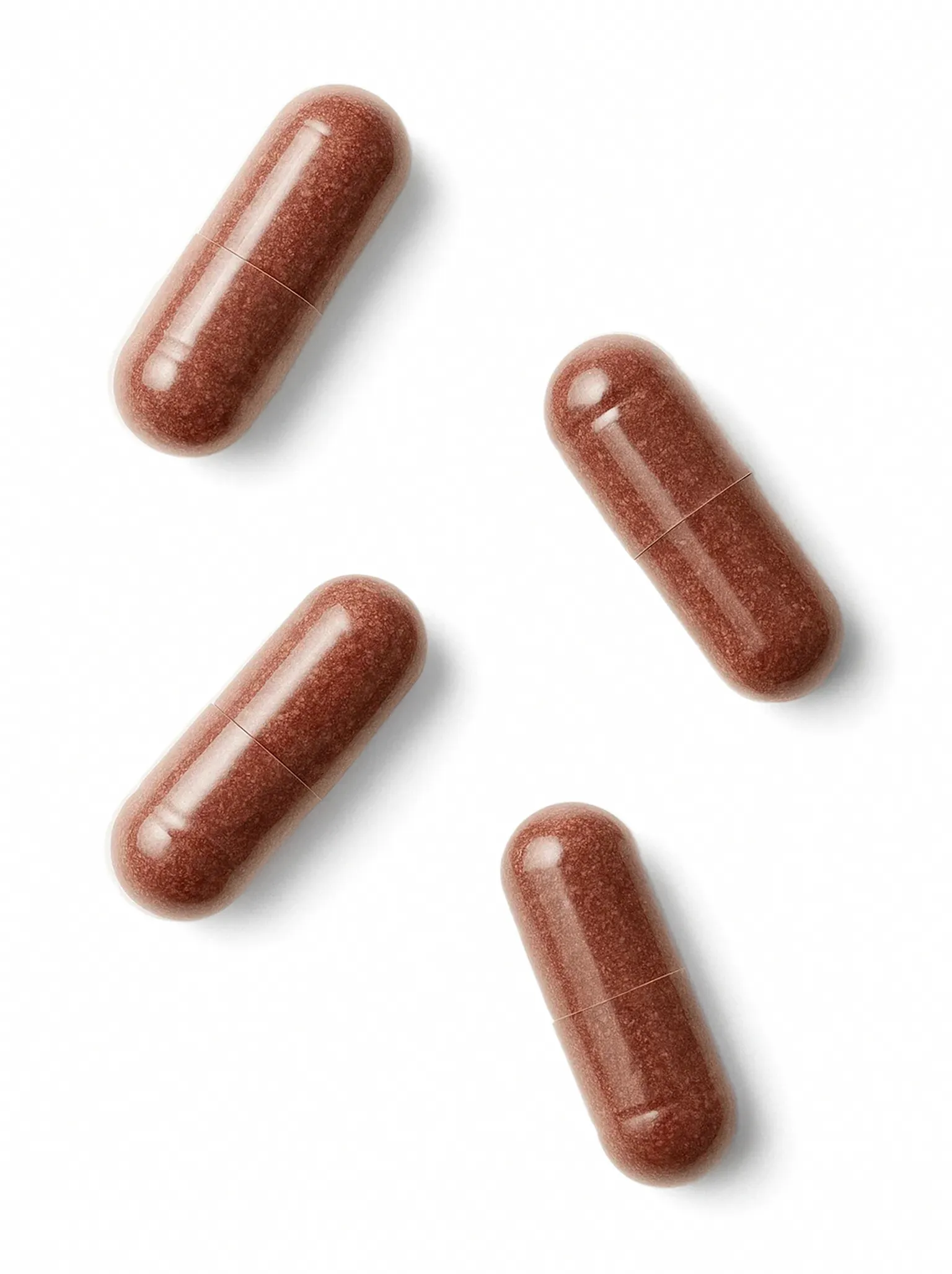 Flat-lay shot of four golden glow tanning capsules