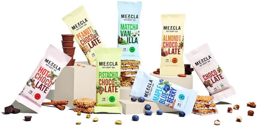 Assorted Mezcla puff-crispy bar packages with nuts and fruit scattered around.