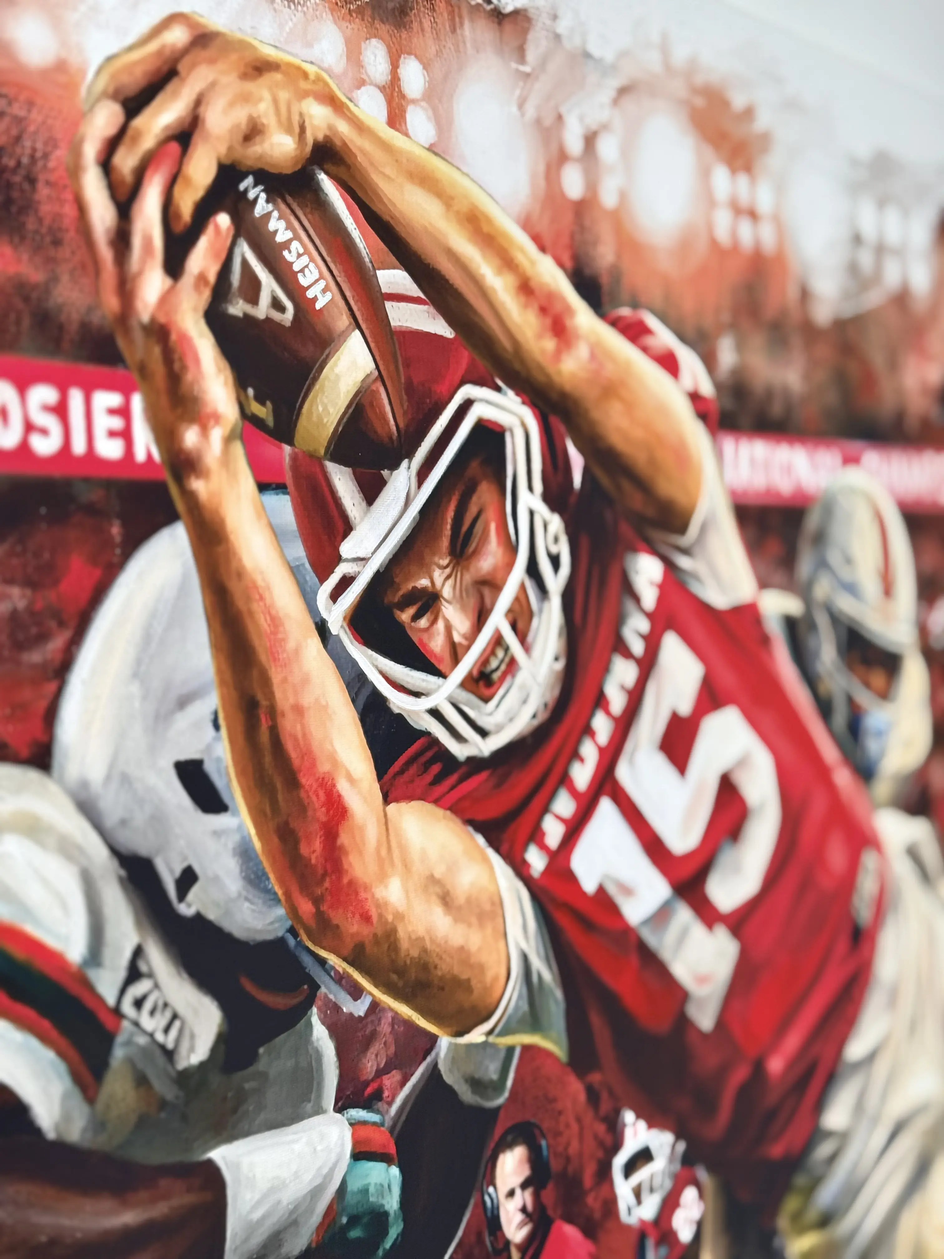 A painting of a football player in a red jersey catching a football with an intense expression.