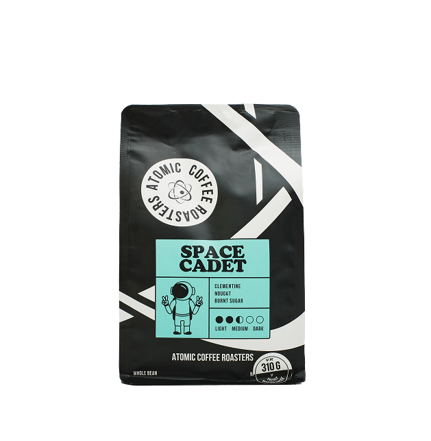 Black coffee bag labeled 'Space Cadet' with astronaut graphic and flavor notes.