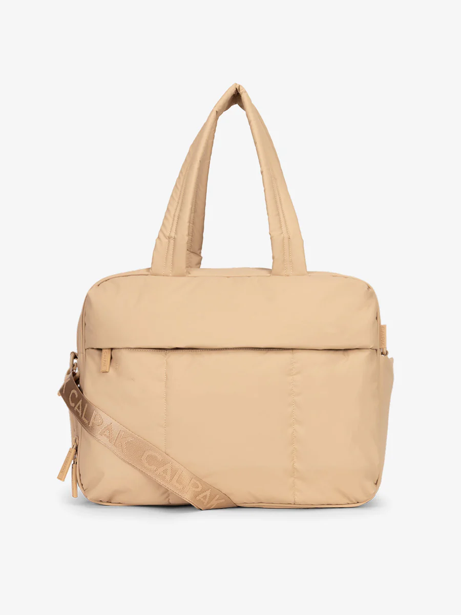 Beige tote bag with handles and a CALPAK branded strap.