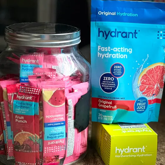 A jar of Hydrant hydration packets next to a pouch and a box of the same product.