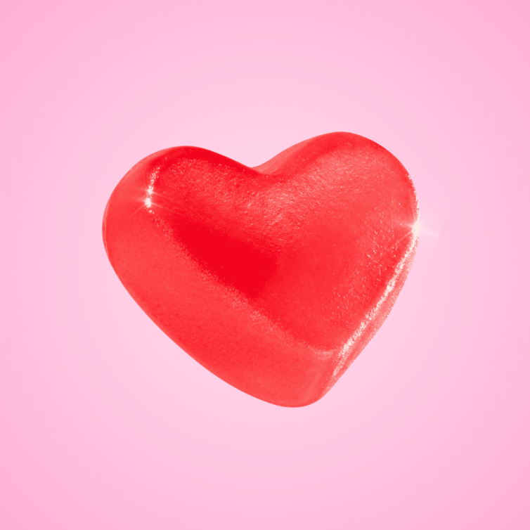 Red heart-shaped object on a pink background.