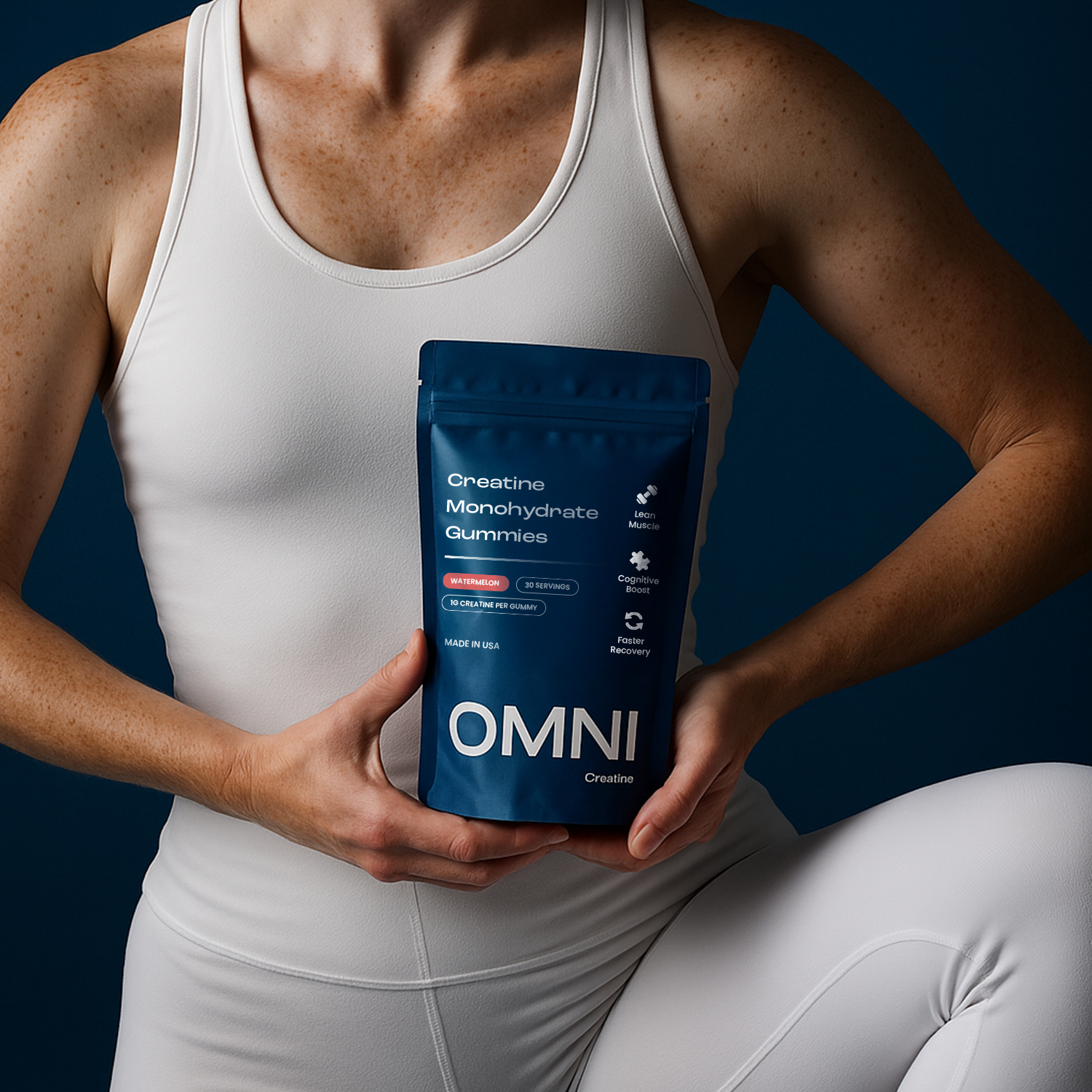 Person in white holding a blue bag of creatine monohydrate gummies.
