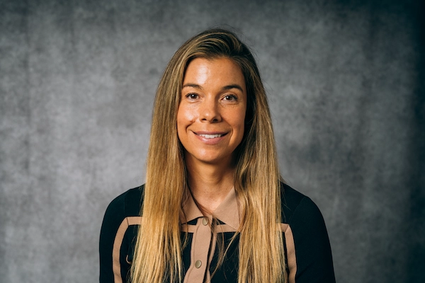 Person smiling against a gray background.