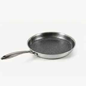 A stainless steel frying pan with a dark, textured honeycomb cooking surface on a white background.