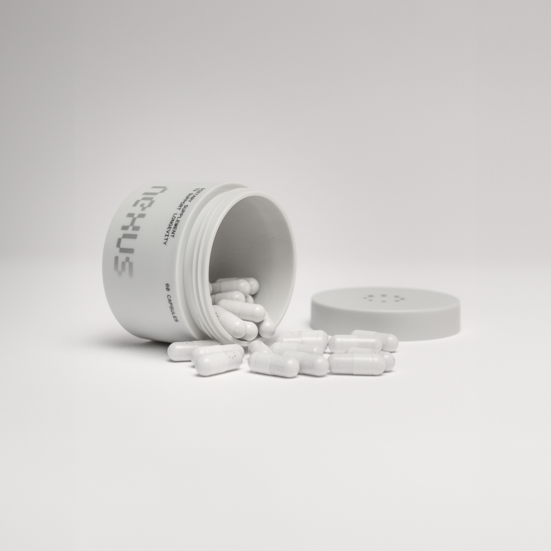 Open white pill bottle with capsules spilled out.