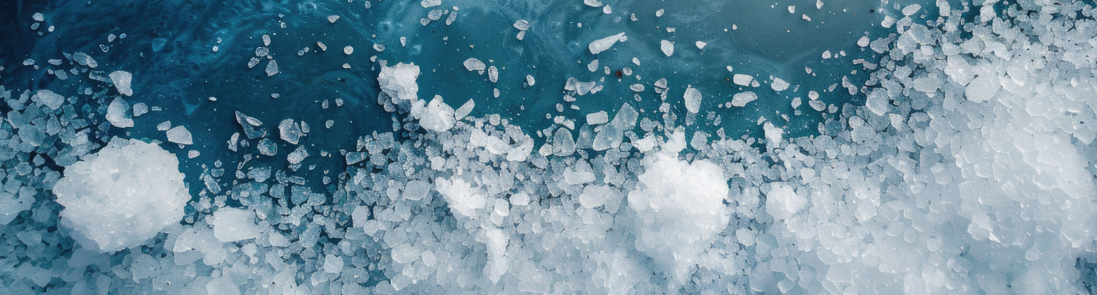 Close-up of ice crystals floating on dark blue water.