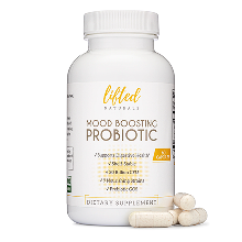 White probiotic supplement bottle with scattered capsules beside it.