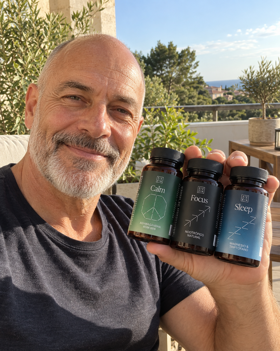 A smiling man holds three bottles of supplements labeled Calm, Focus, and Sleep while sitting outdoors.