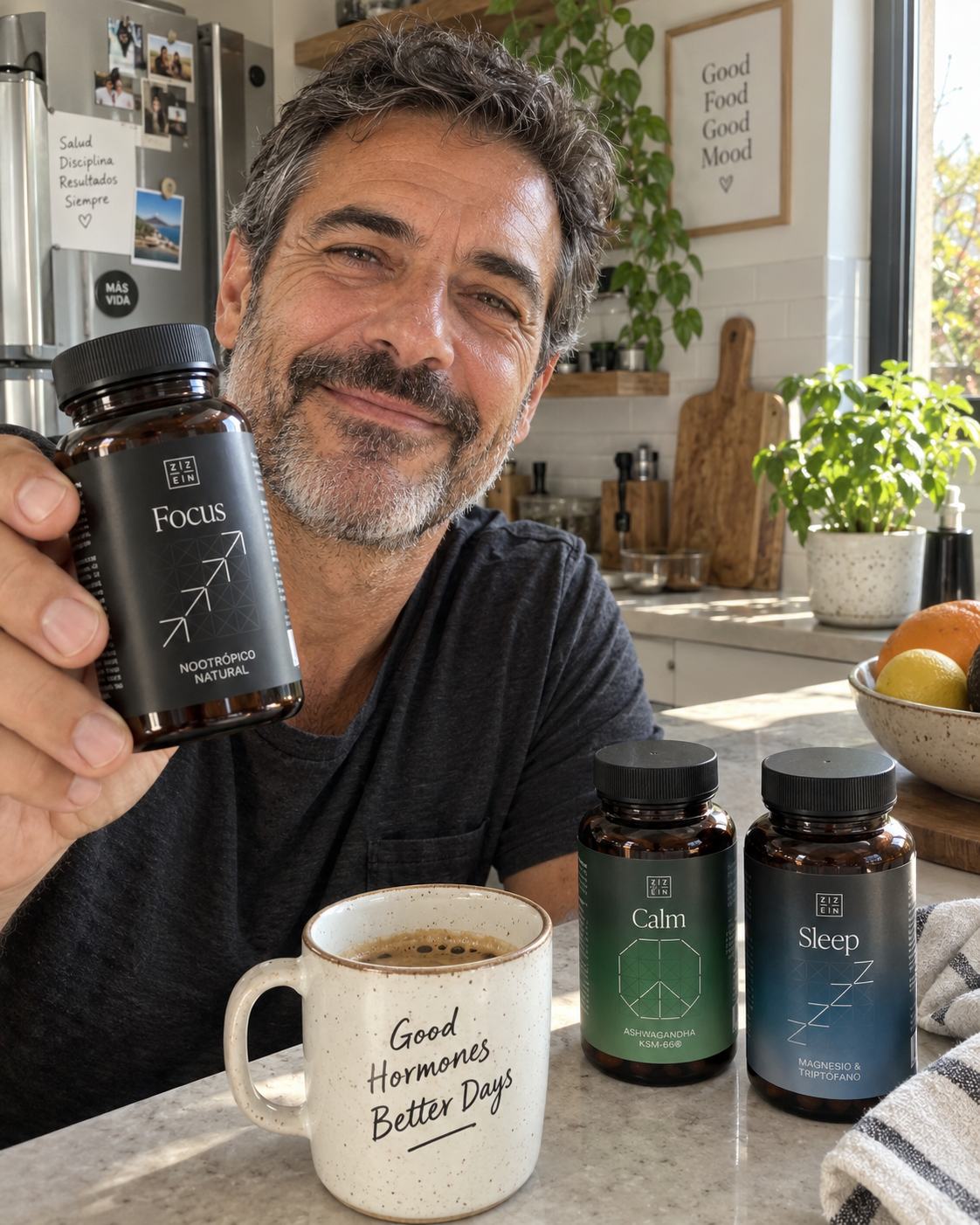 A smiling man in a kitchen holds up a bottle of 'Focus' supplements, with other supplement bottles nearby.