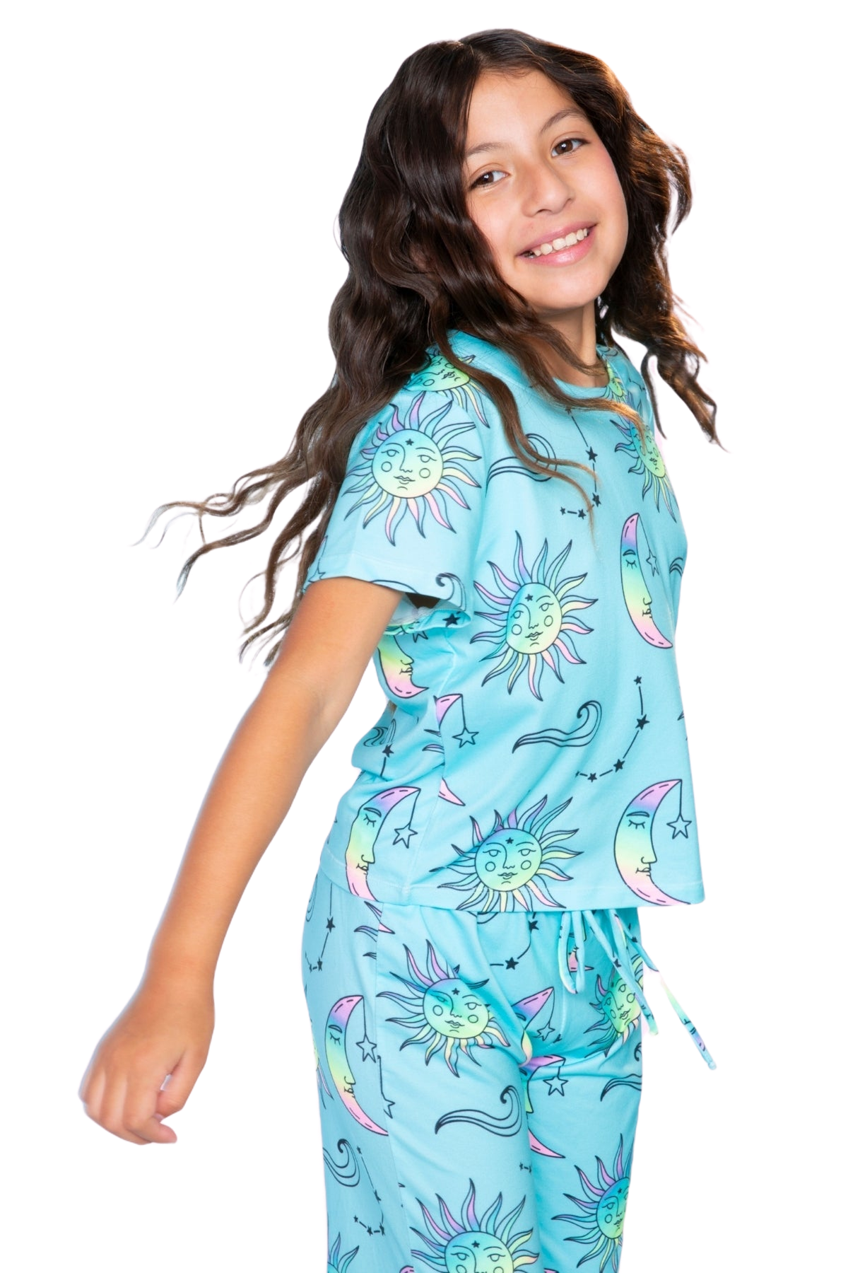 Child in sun and moon patterned blue pajamas, smiling.