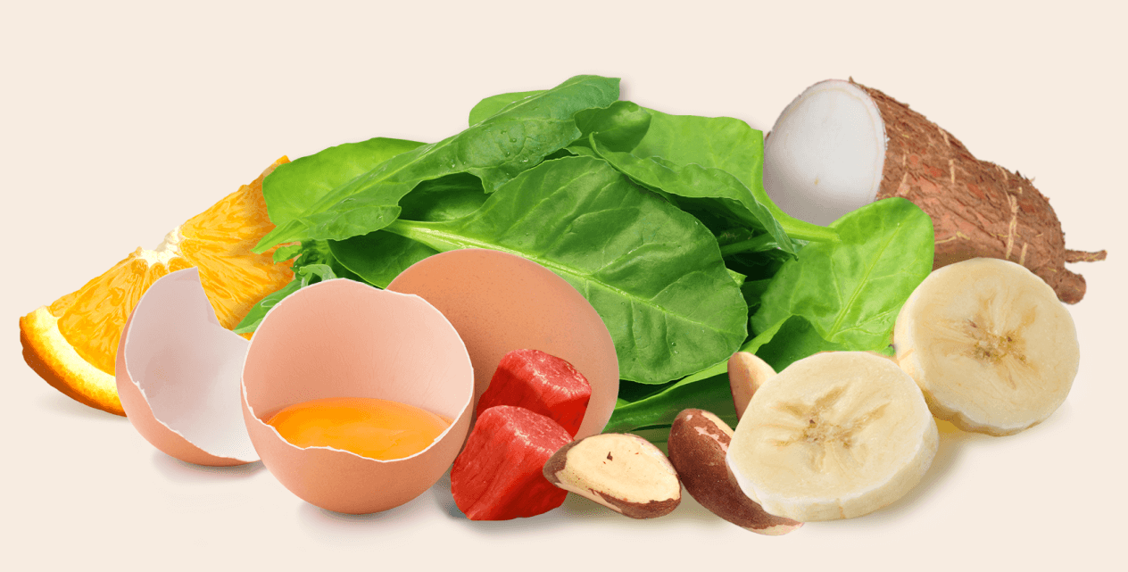 A collection of various foods including spinach, eggs, an orange slice, meat, nuts, banana, and yucca root.