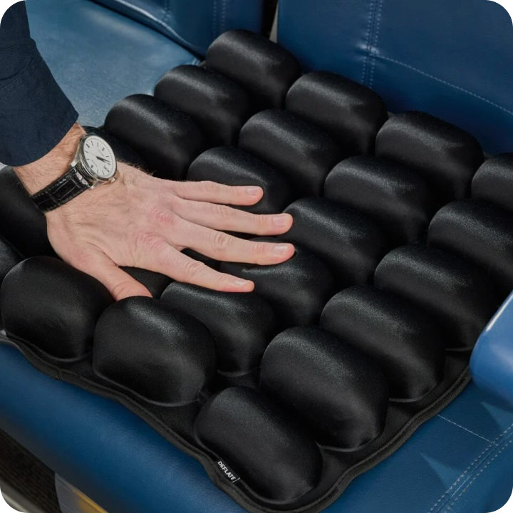 Hand pressing on a black cushion with individual pods on a blue seat.