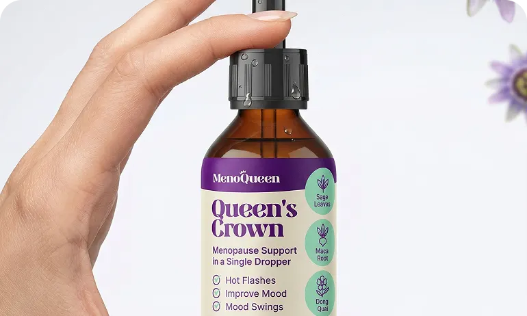 A hand holds a dropper over a bottle of MenoQueen Queen's Crown menopause support supplement.
