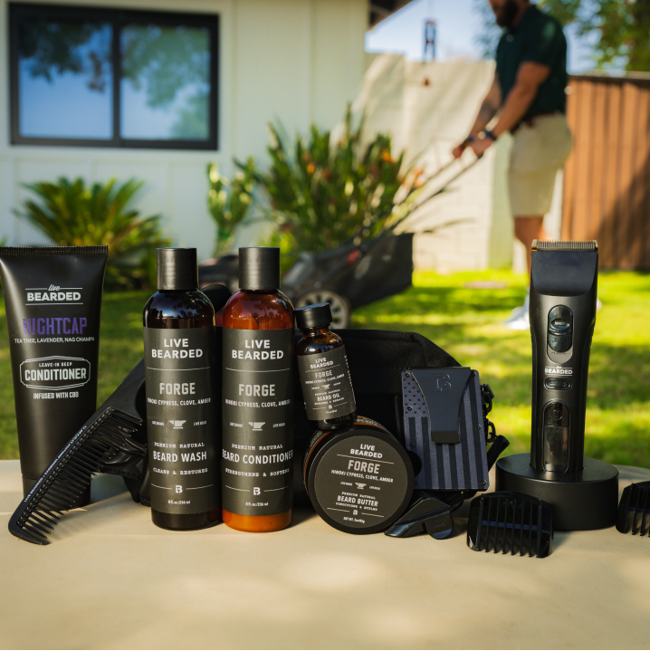 Beard grooming products displayed on a table with a person mowing the lawn in the background.