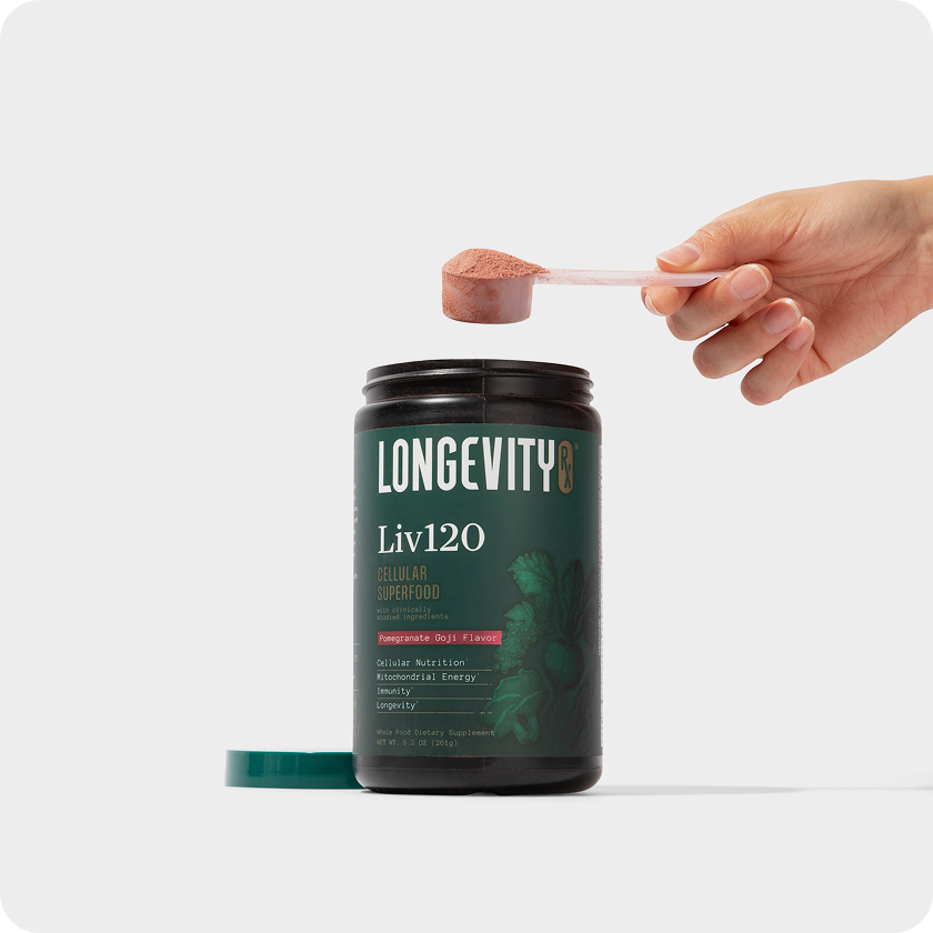 Hand holding scoop above Longevity Liv120 supplement container.