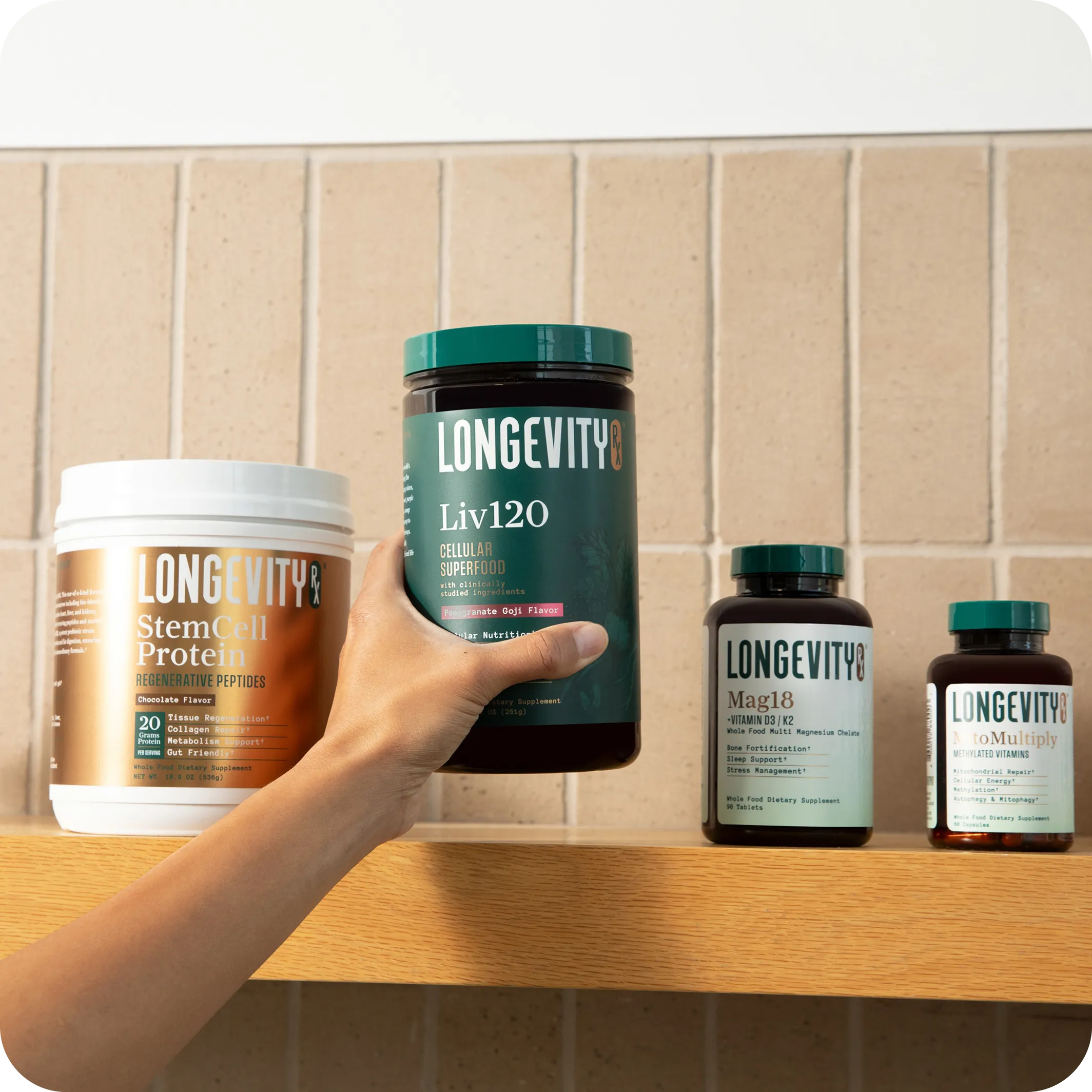 A hand reaches for a Longevity RX supplement container on a wooden shelf with other similar products.