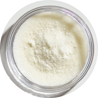 A clear bowl filled with white powder, viewed from above.