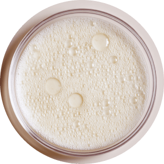 Petri dish with white foamy liquid and bubbles.