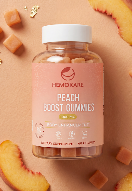 A hand holds a bottle of Hemokare Peach Boost Gummies against a solid pink background.
