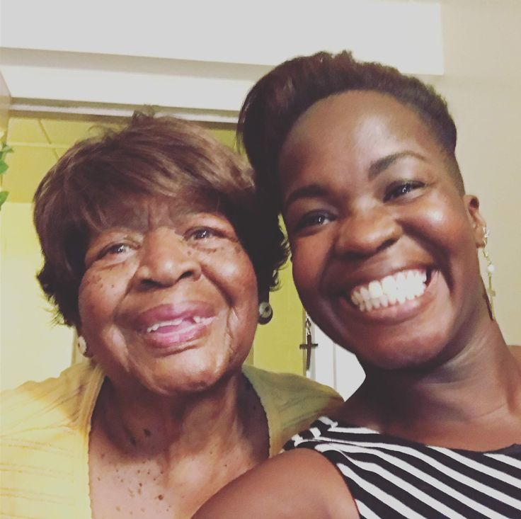 A close-up of a younger woman and an older woman smiling together for a photo.