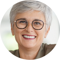 Person with short gray hair and glasses smiling.
