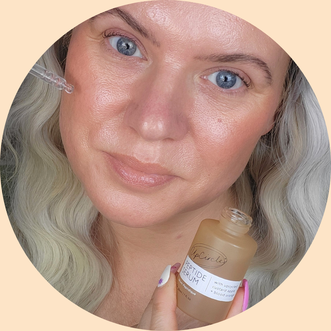 Person applying serum to face with a dropper.