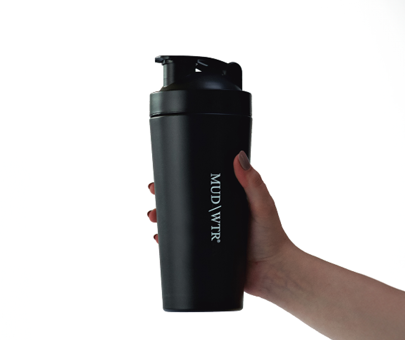 Hand holding a black MUD\WTR shaker bottle against a white background.