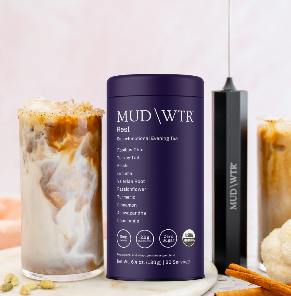 MUD\WTR Rest tea container with iced drink and frother on a marble surface.