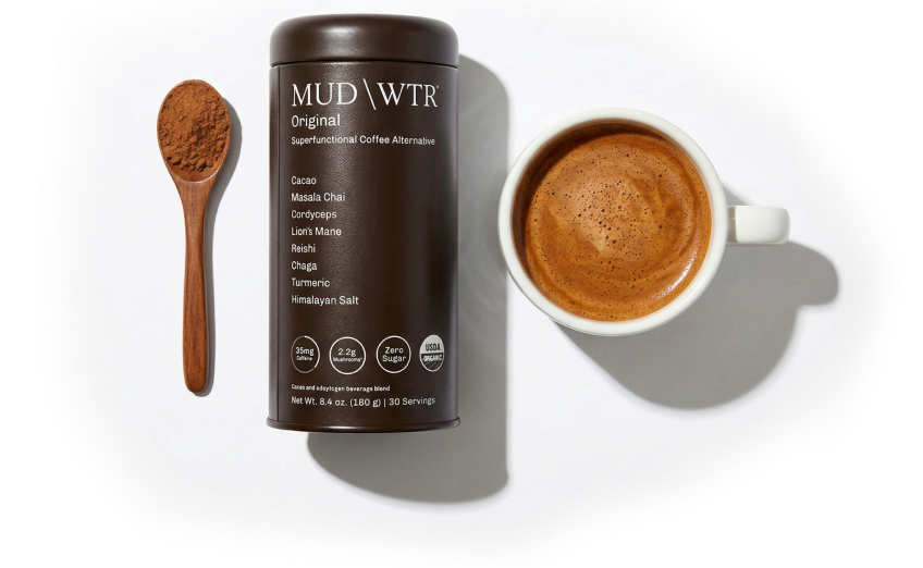 A can of MUD\WTR coffee alternative, a spoonful of powder, and a prepared mug of the drink.