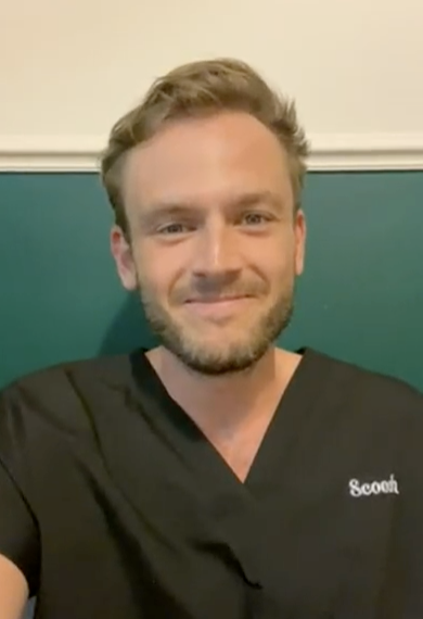 Person in black scrubs smiling against a teal background.