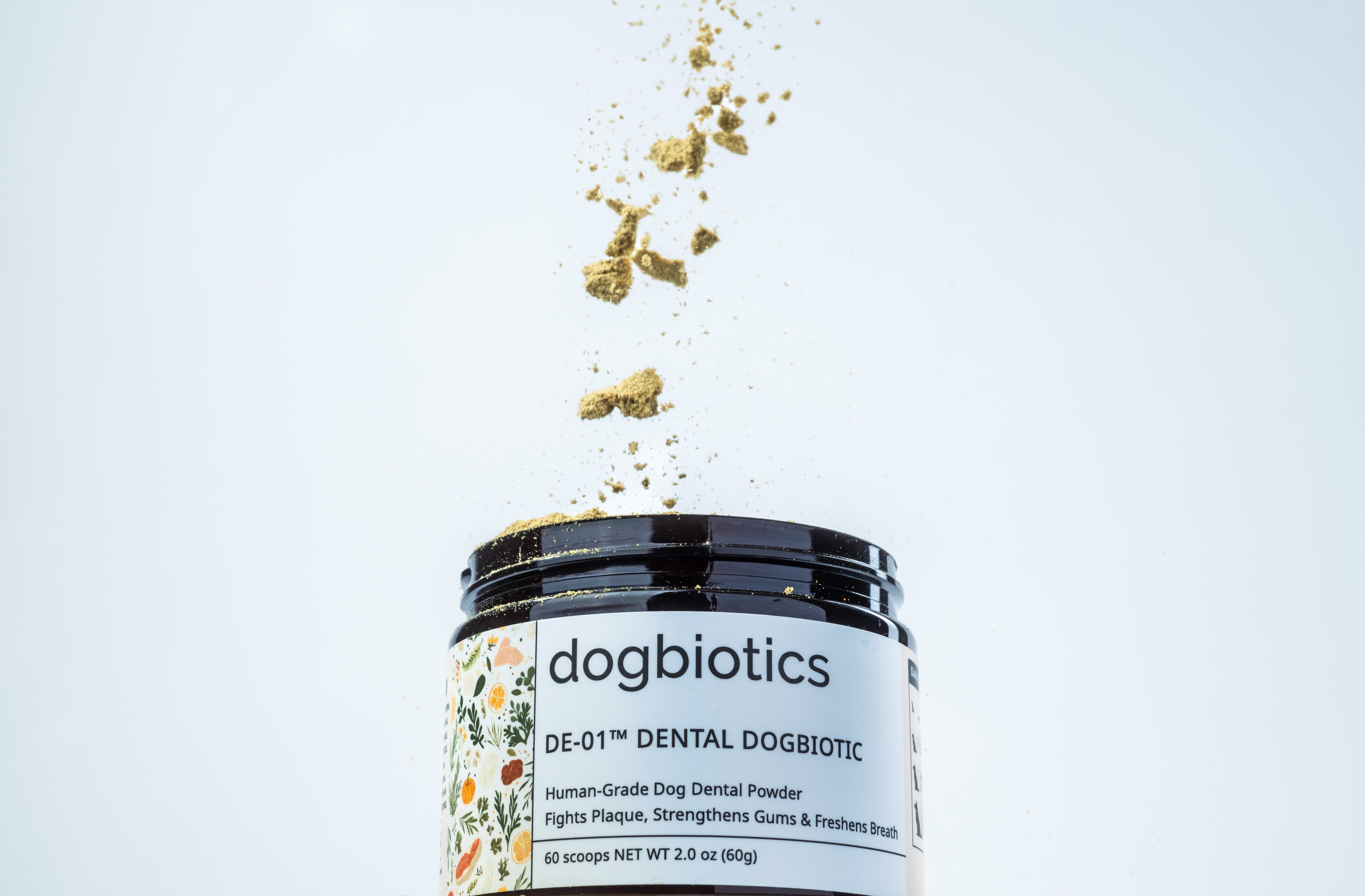 Dog dental powder spilling from open jar on white background.