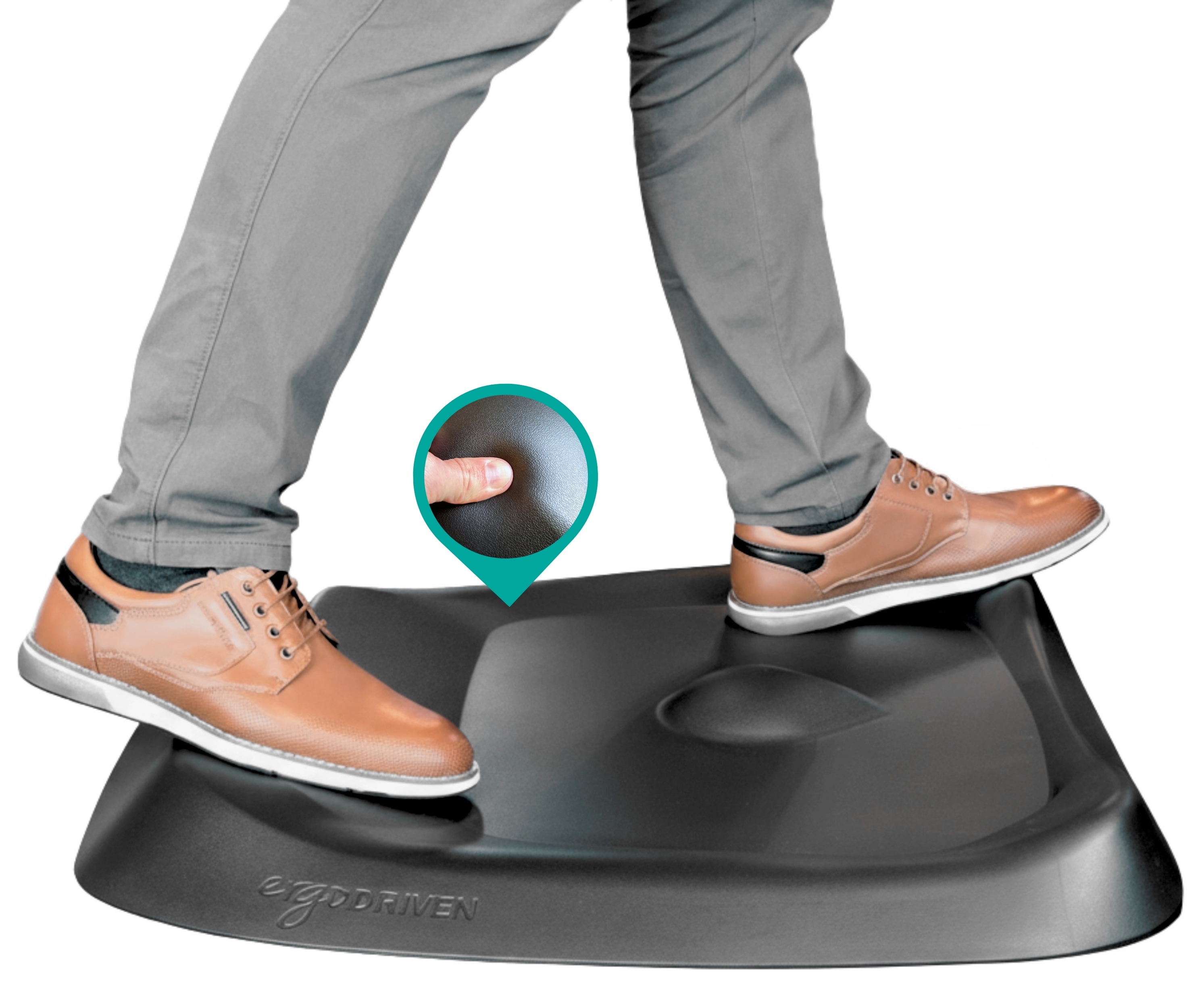 Person standing on an ergonomic mat with brown shoes.