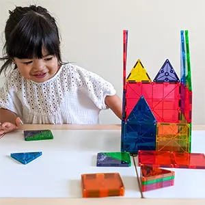 Child playing with colorful magnetic building blocks.
