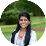 Smiling person outdoors with trees in the background.