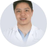 Person in a white coat against a plain background.