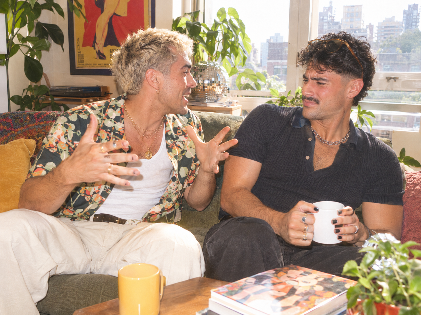 Two men on a couch, one telling a story while the other pulls back slightly