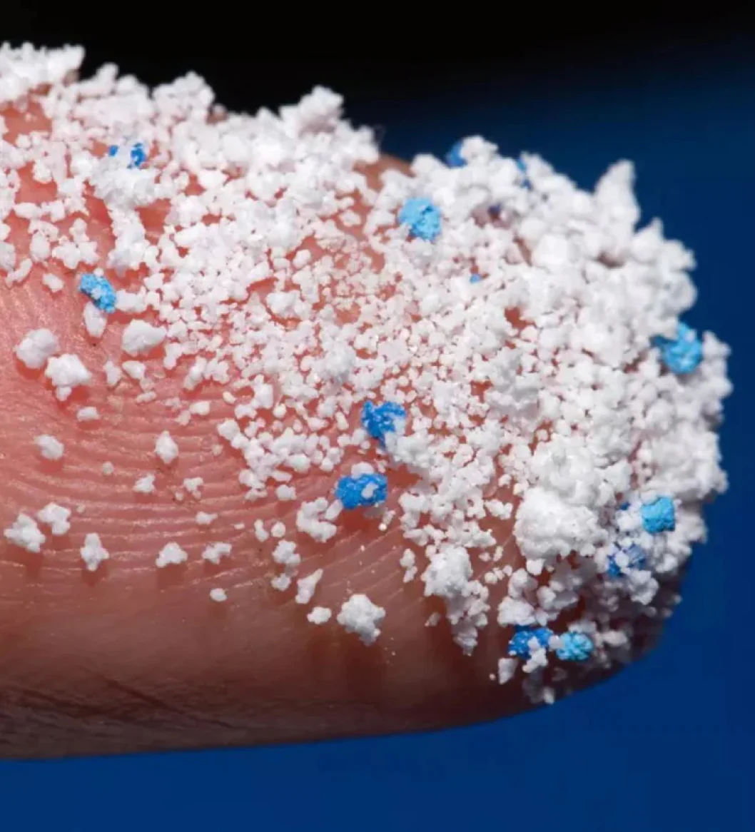 Close-up of a finger covered in white and blue granules.