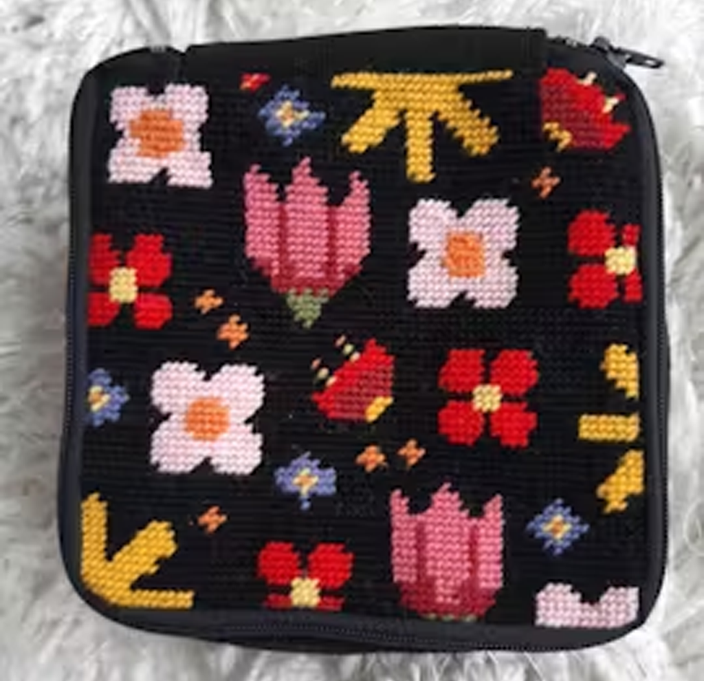 Black pouch with colorful embroidered flowers and geometric patterns.