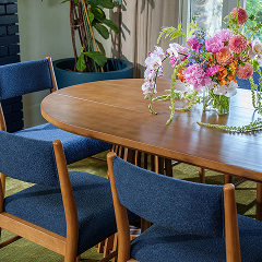 Modern dining table with navy blue upholstered chairs.