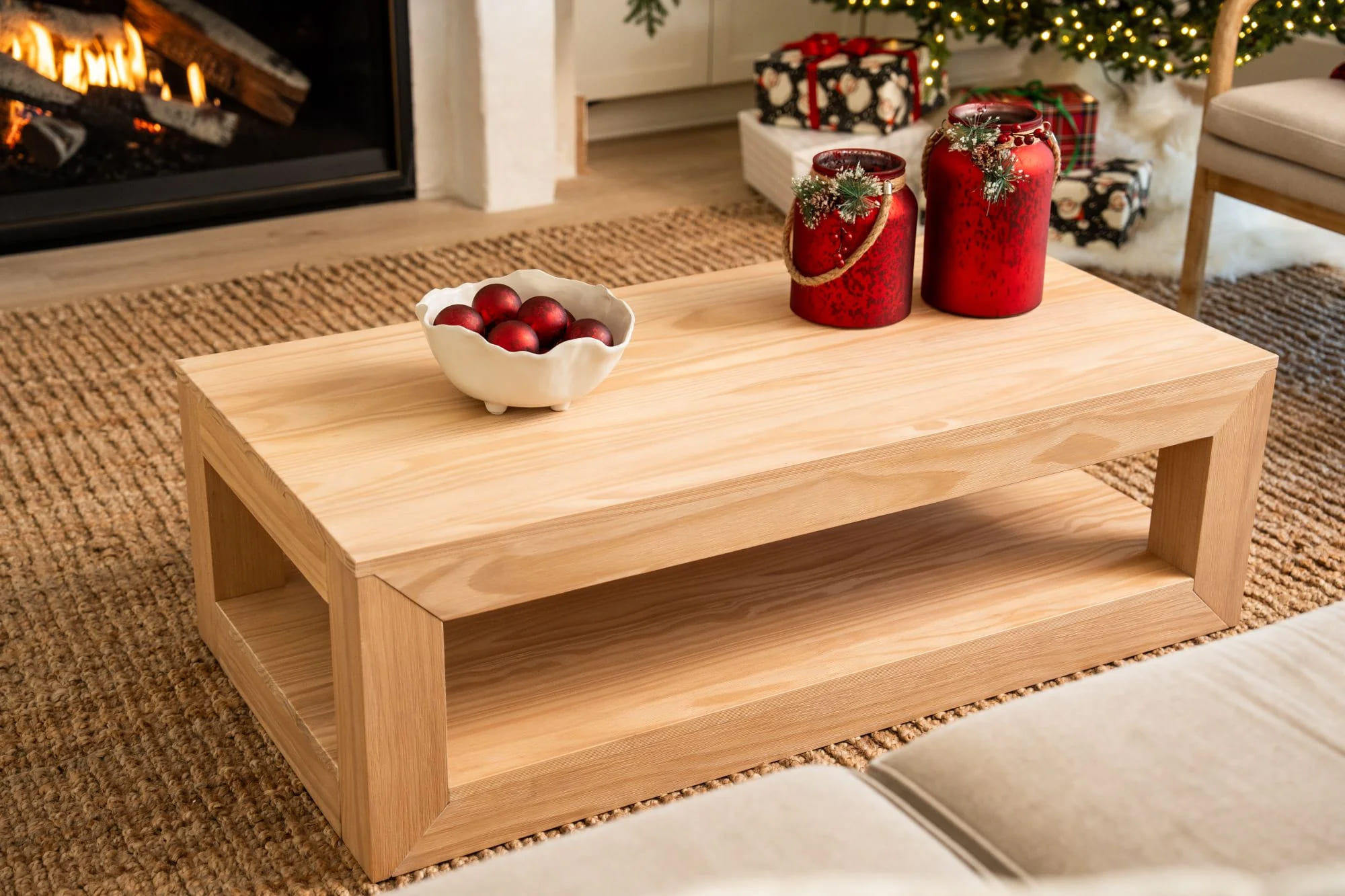Blonde coffee table with red holiday accent decor.