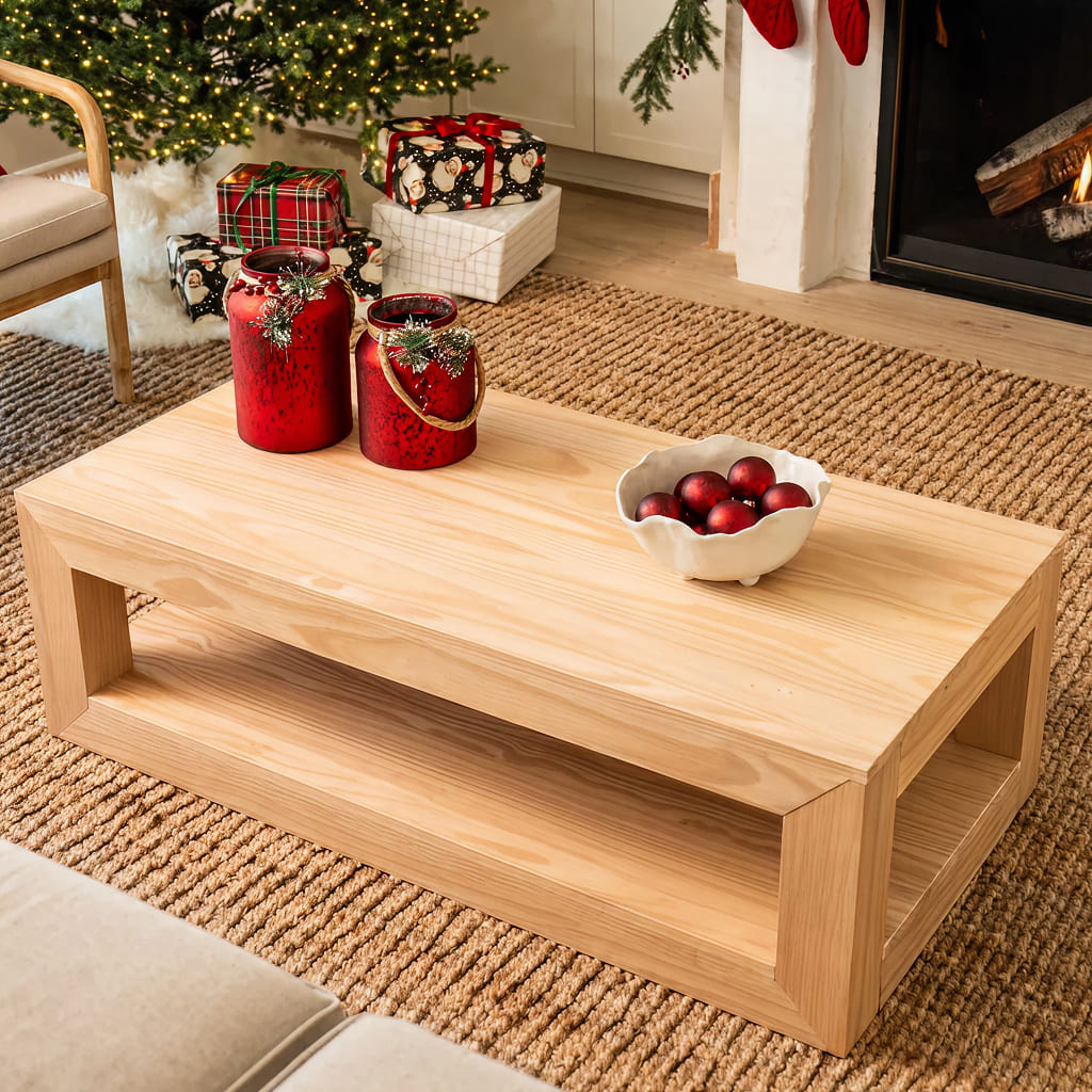 Bright, holiday living room with red decor on top of a blonde, modern coffee table.