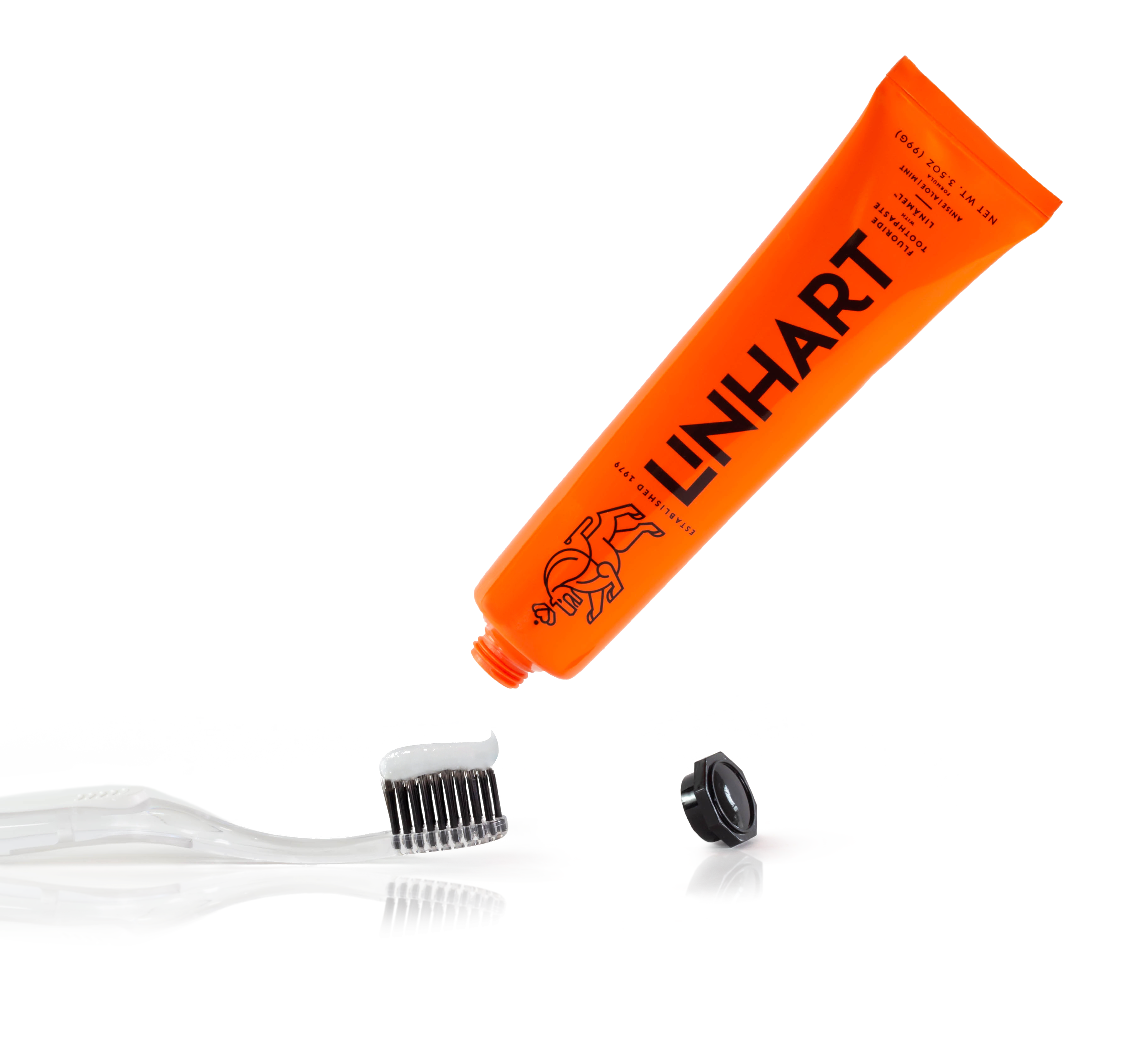 Orange toothpaste tube above a toothbrush with black bristles and a detached cap.