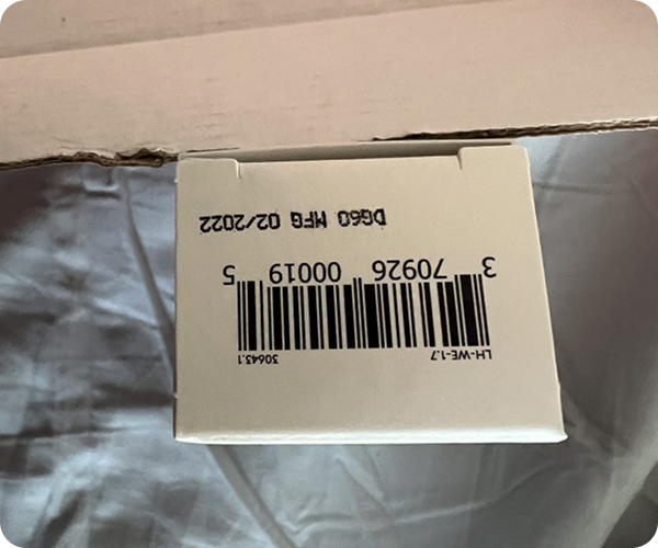 White box with a barcode and printed expiration date.