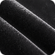 A close-up of folded, plush black velvet fabric.