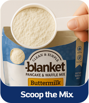 A hand scooping buttermilk pancake and waffle mix from a blue and white bag.