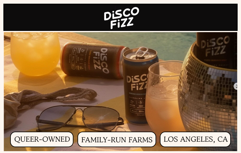 Disco Fizz cans and cocktails arranged poolside on a towel with sunglasses and a disco ball cooler.