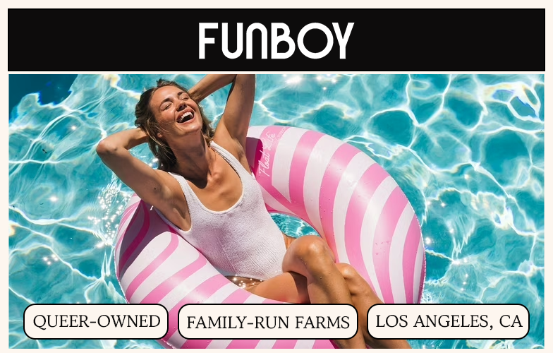 A woman in a white swimsuit laughs while floating in a pool on a pink and white striped ring.